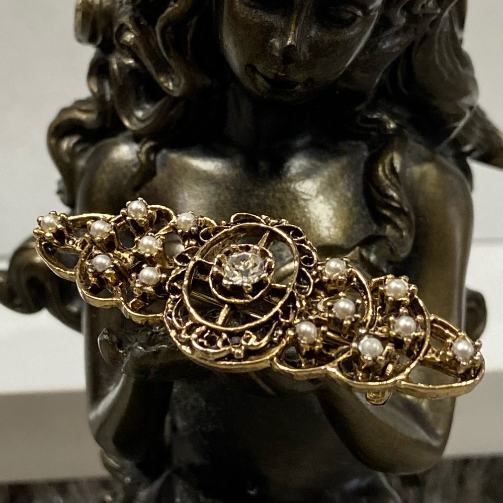 Vintage women aged gold tone pearl and white rhinestone brooch pin.
